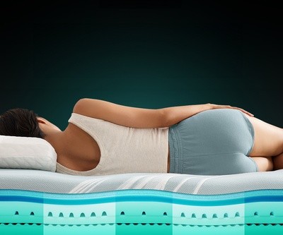Woman laying on an Adapt mattress, with graphics showing the layers inside the mattress
