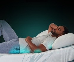 man laying on Adapt mattress with green highlights on his hip, elbow, and shoulder to show pressure relief