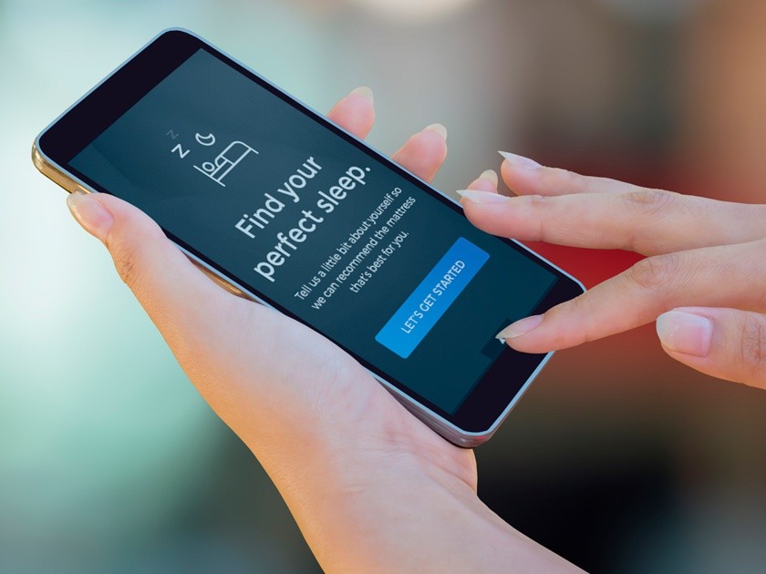 Hands holding phone with text visible that states "find your perfect sleep"