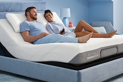 A couple on a Tempur-Pedic mattress enjoying the Zero Gravity Preset feature