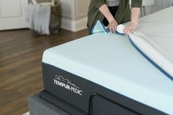 a person pulling the top cover off of a mattress