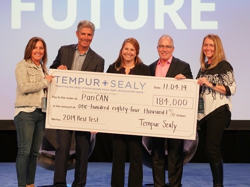 group of people holding a check made out to PanCan