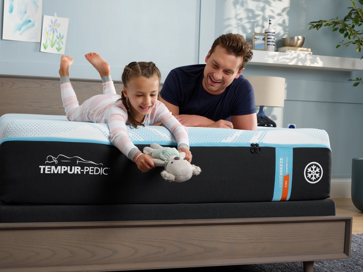 Man and child on a Luxebreeze mattress in a decorated room