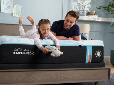 Man and child on a Luxebreeze mattress in a decorated room