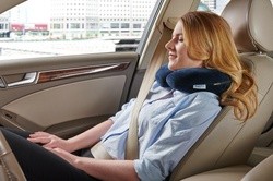 A woman in a car with a TEMPUR-Travel Pillow