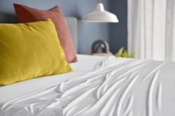 White TEMPUR-Sheets on a mattress in a fully dressed room