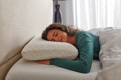 Woman laying on her stomach on a TEMPUR-Cloud Pillow