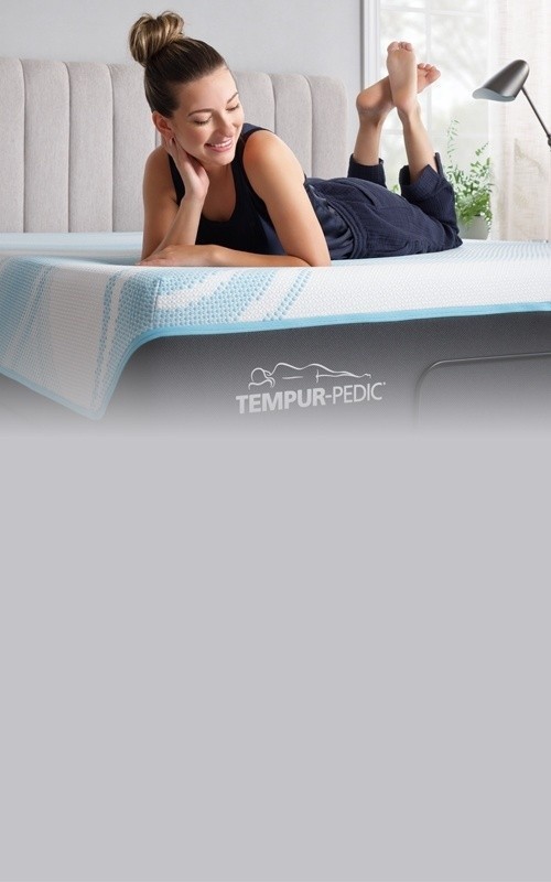 Woman lounging on her Tempur mattress - Mobile View