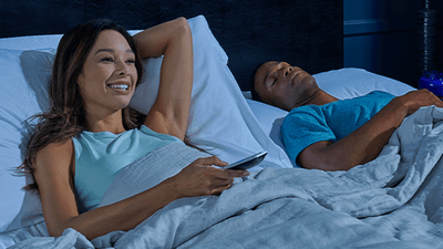 Couple laying on mattress with woman's head raised