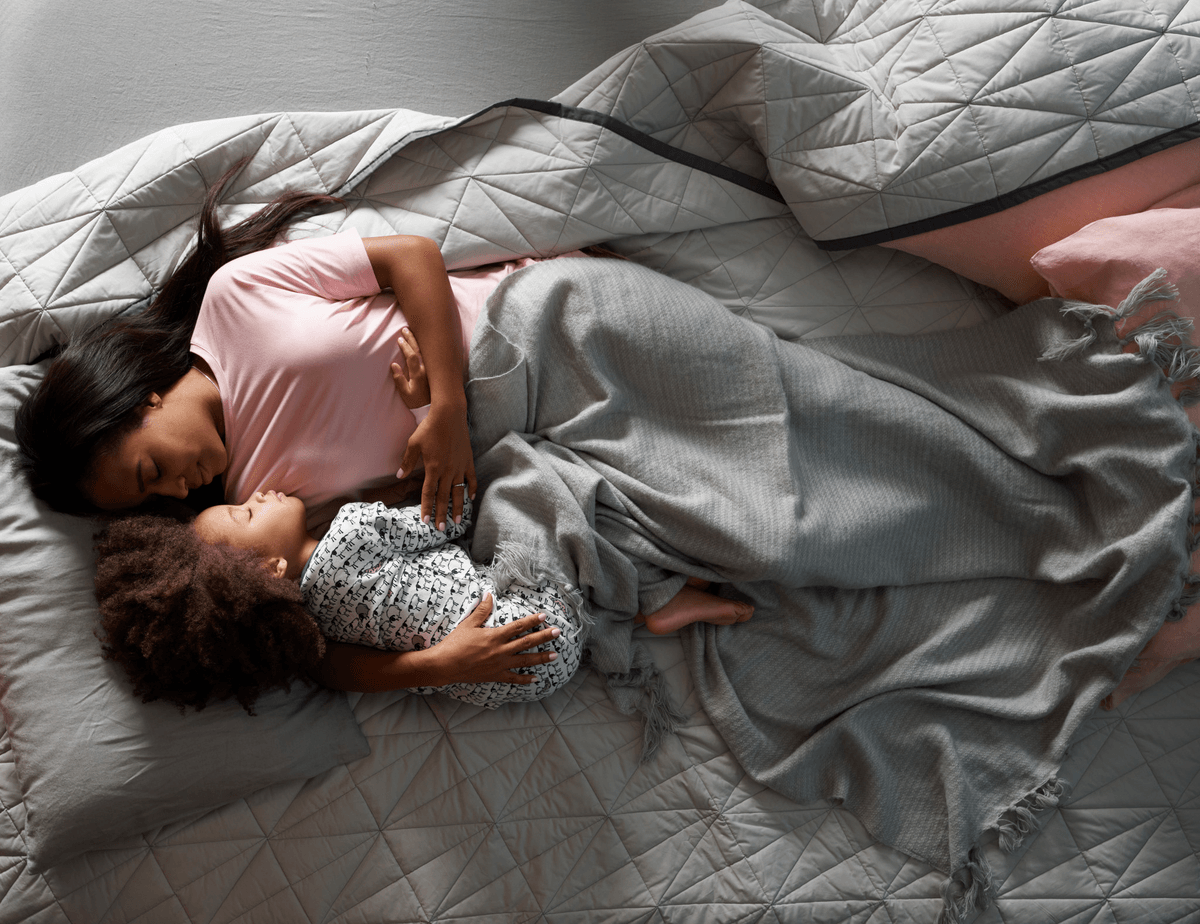 Woman and child sleeping on mattress