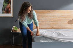 woman putting on mattress protector