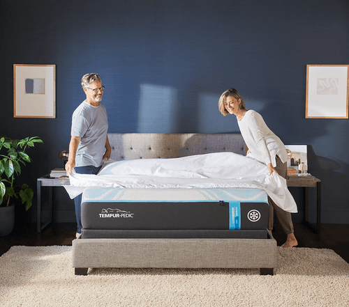 Couple in a fully dressed bedroom, putting sheets on their Queen, Soft, LuxeBreeze mattress - medium screens