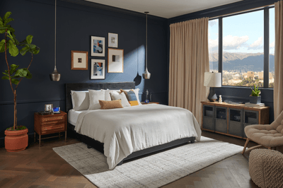 Dressed bed in navy bedroom with large window