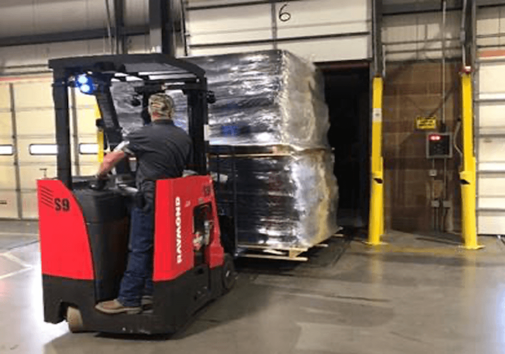 man on a forklift lifting mattresses.png