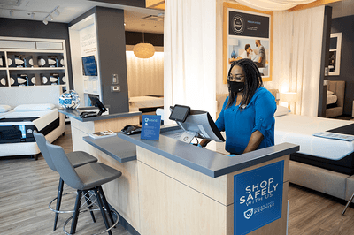 Woman with face mask standing behind cash register