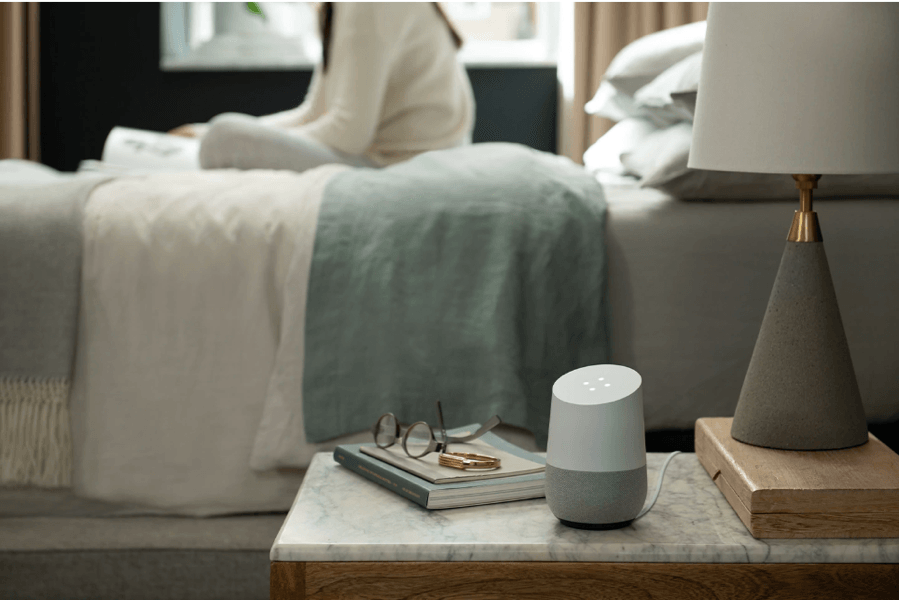 Google Home sitting on woman&#x27;s nightstand