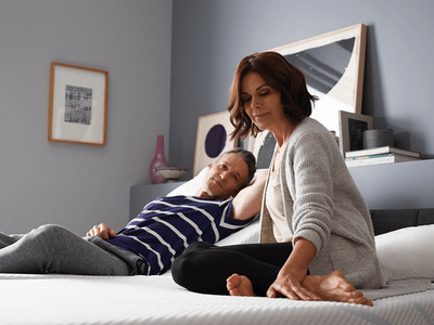 a man and woman sitting on a Split King mattress