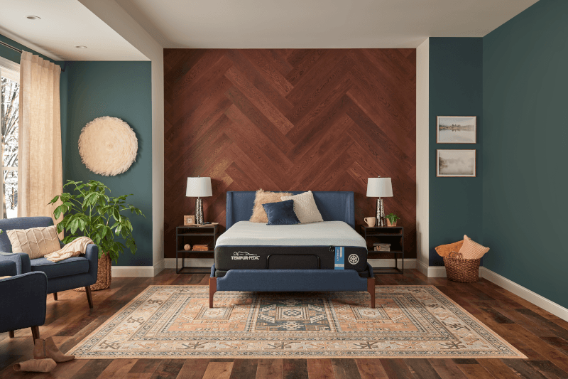 LuxeBreeze mattress in decorated room with herringbone wooden wall, decorative chairs, and an antique rug